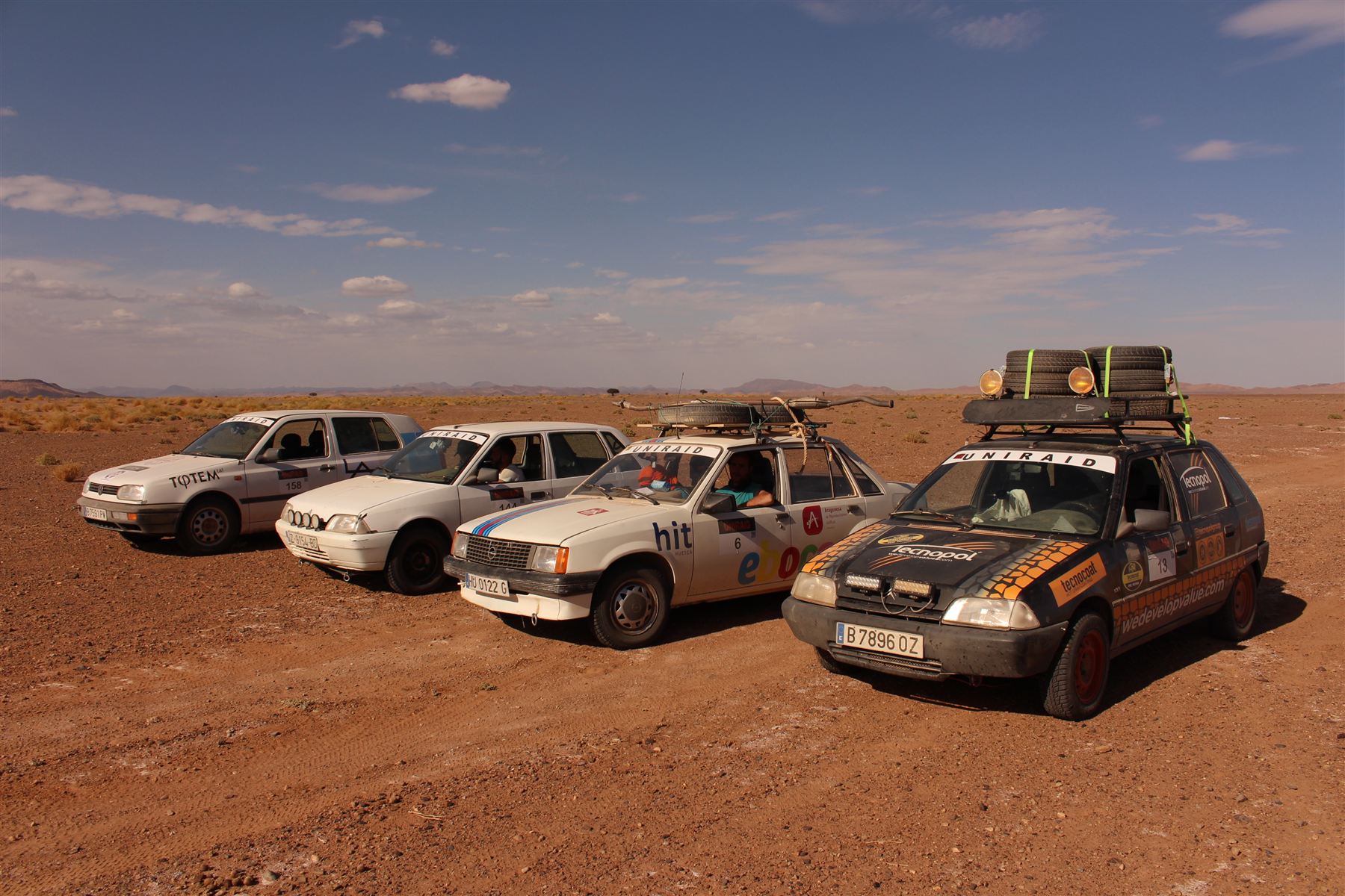 Cuatro vehículos de raid alineados en el desierto